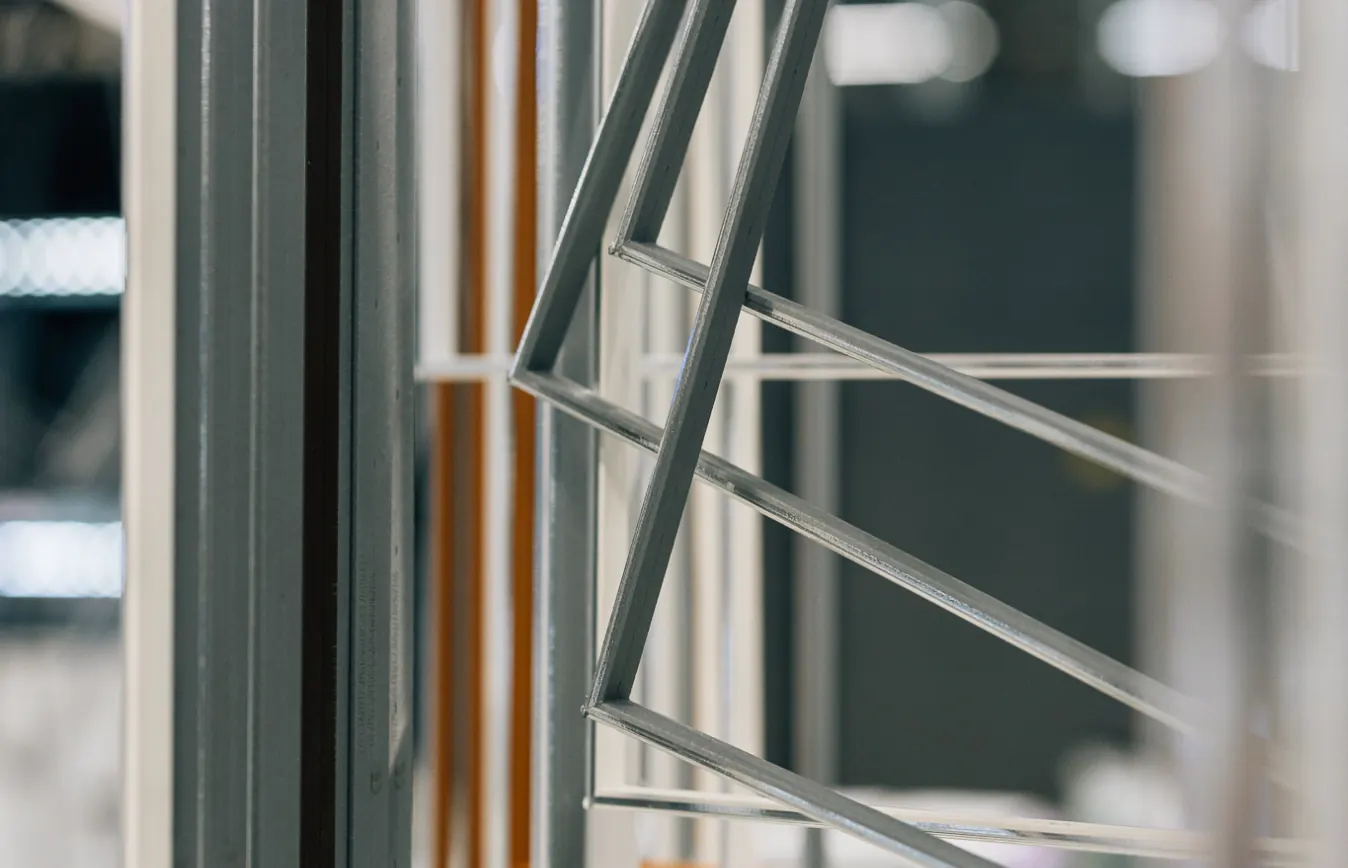 Schmale Metallrahmen und Fensterprofile in einer Werkhalle, Nahaufnahme.
